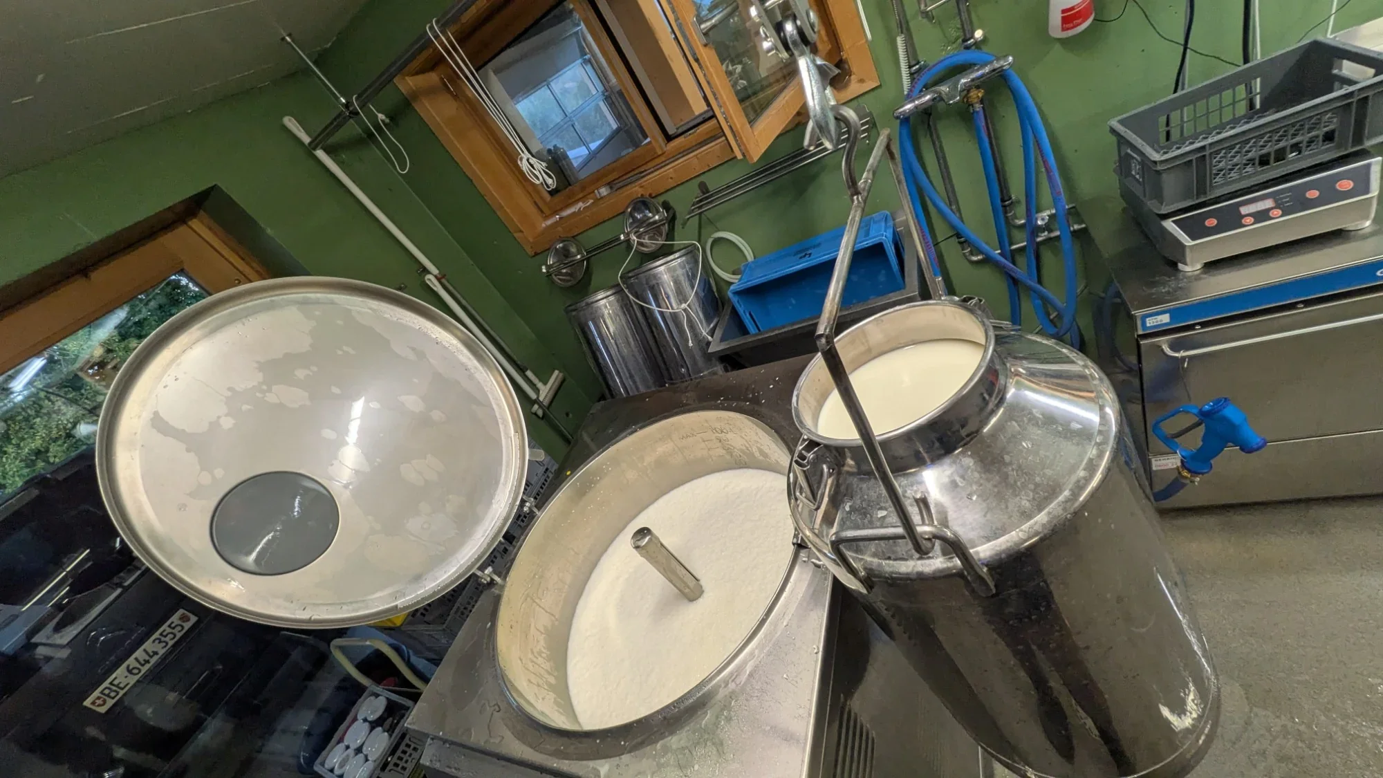 Geöffneter Pasteur mit Milch und aufgehängter Milchkanne in der Milchverarbeitung