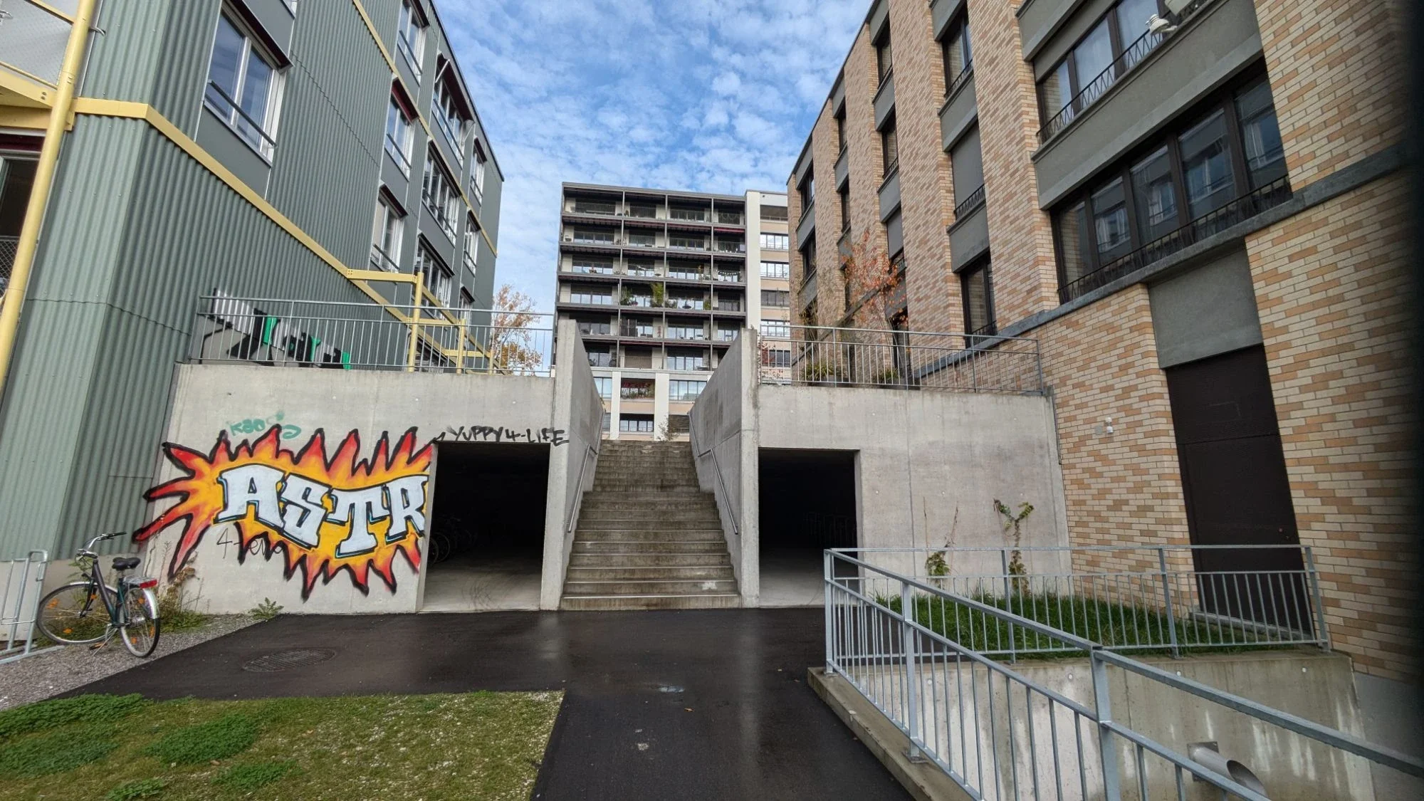 Betontreppe zwischen zwei Wohnhäusern, links und rechts Einfahrten zu Garagen