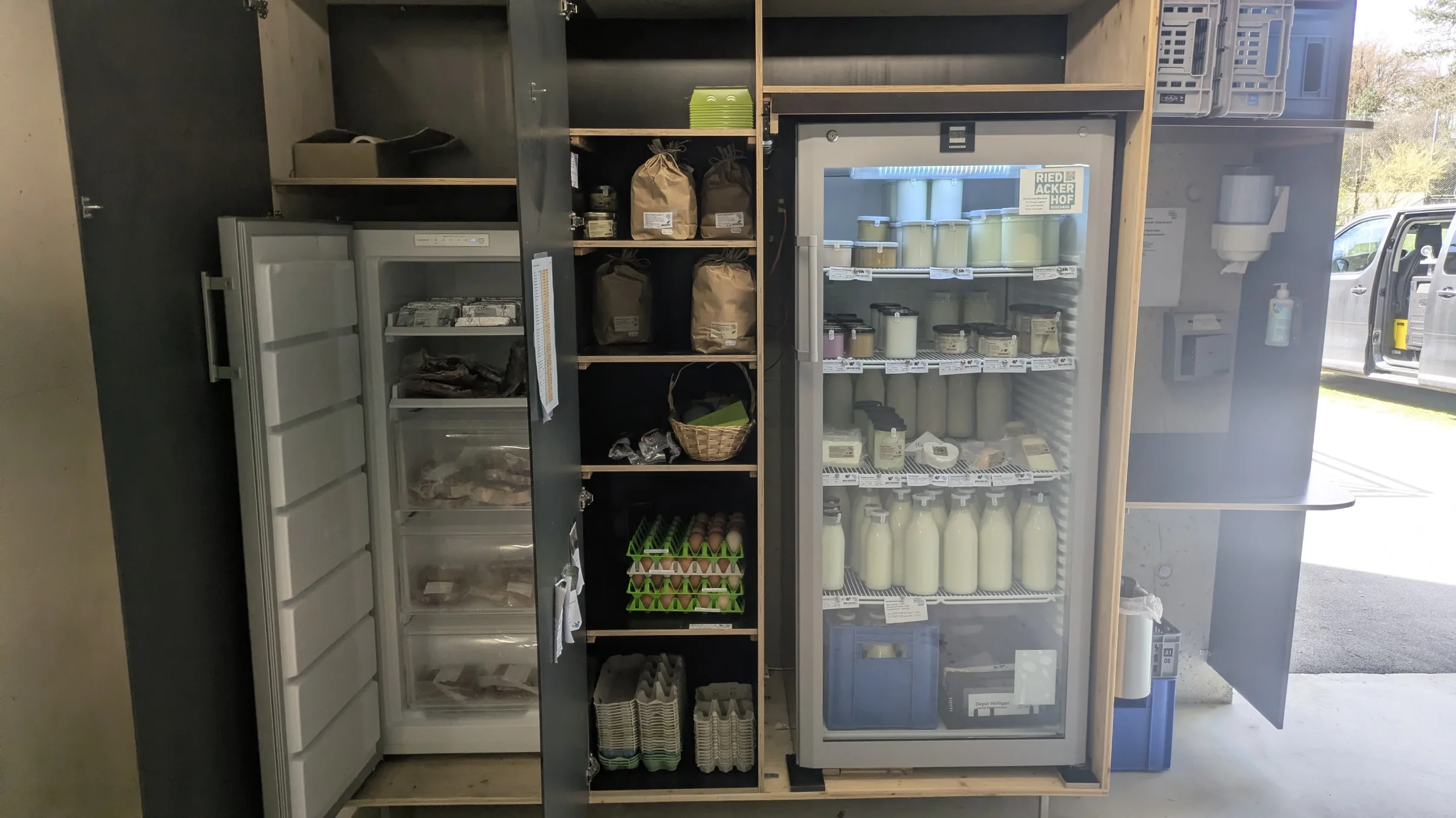 Holzschrank mit zwei Kühlschränken, Milchflaschen, Joghurt und Mehl, die linke Tür steht offen